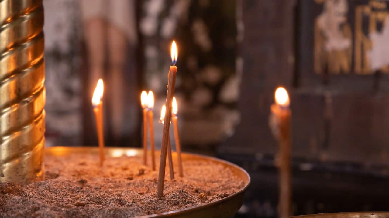 wax candles lit against the background of a cross, the concept of christian religion, prayers for the salvation of the soul, soft focus.Orthodox church, many burning candles in temple