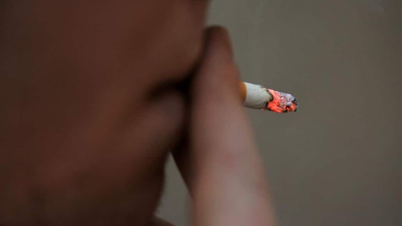 A man smoking a cigarette.