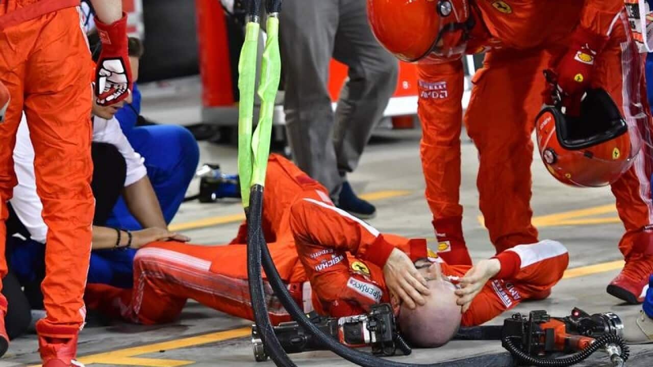 A mechanic of Scuderia Ferrari lays down after he was hit.