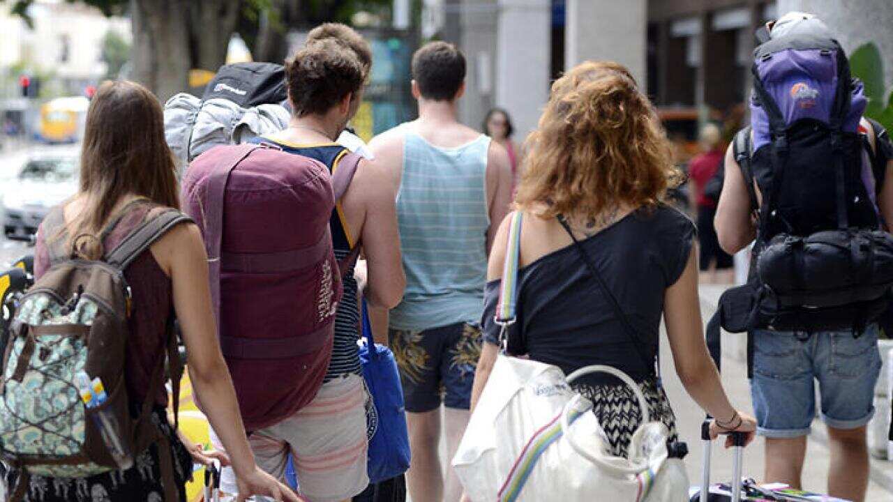 Backpackers walk through the streets of Brisbane