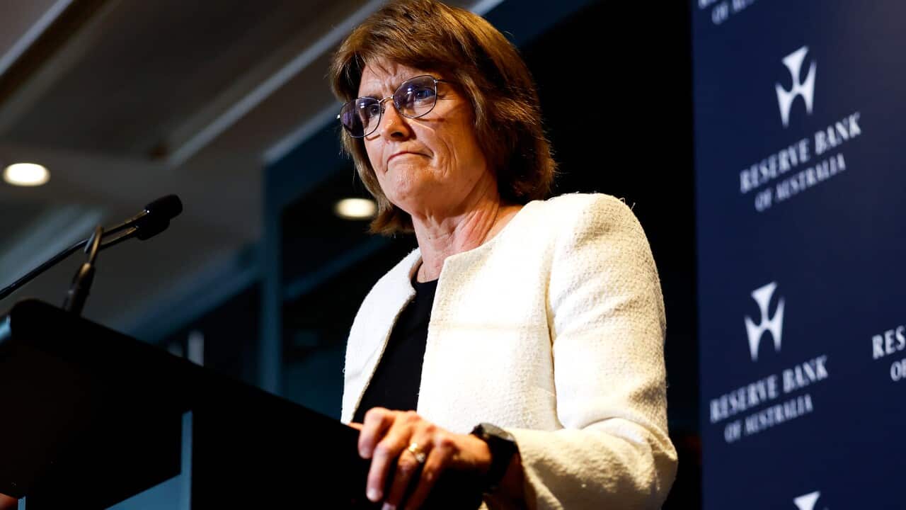 A woman speaking while standing at a lectern.
