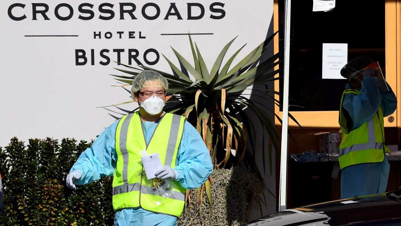 NSW Health workers dressed in Personal Protective Equipment (PPE) are seen administering COVID-19 tests to people in their cars at the Crossroads Hotel testing centre in Sydney, Monday, July 13, 2020. (AAP Image/Joel Carrett) NO ARCHIVING