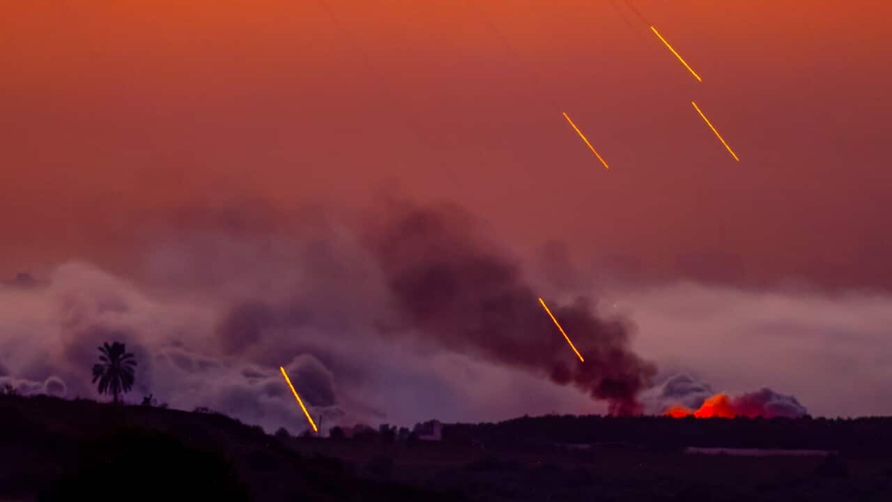 Artillery rains down against a reddish-orange sky