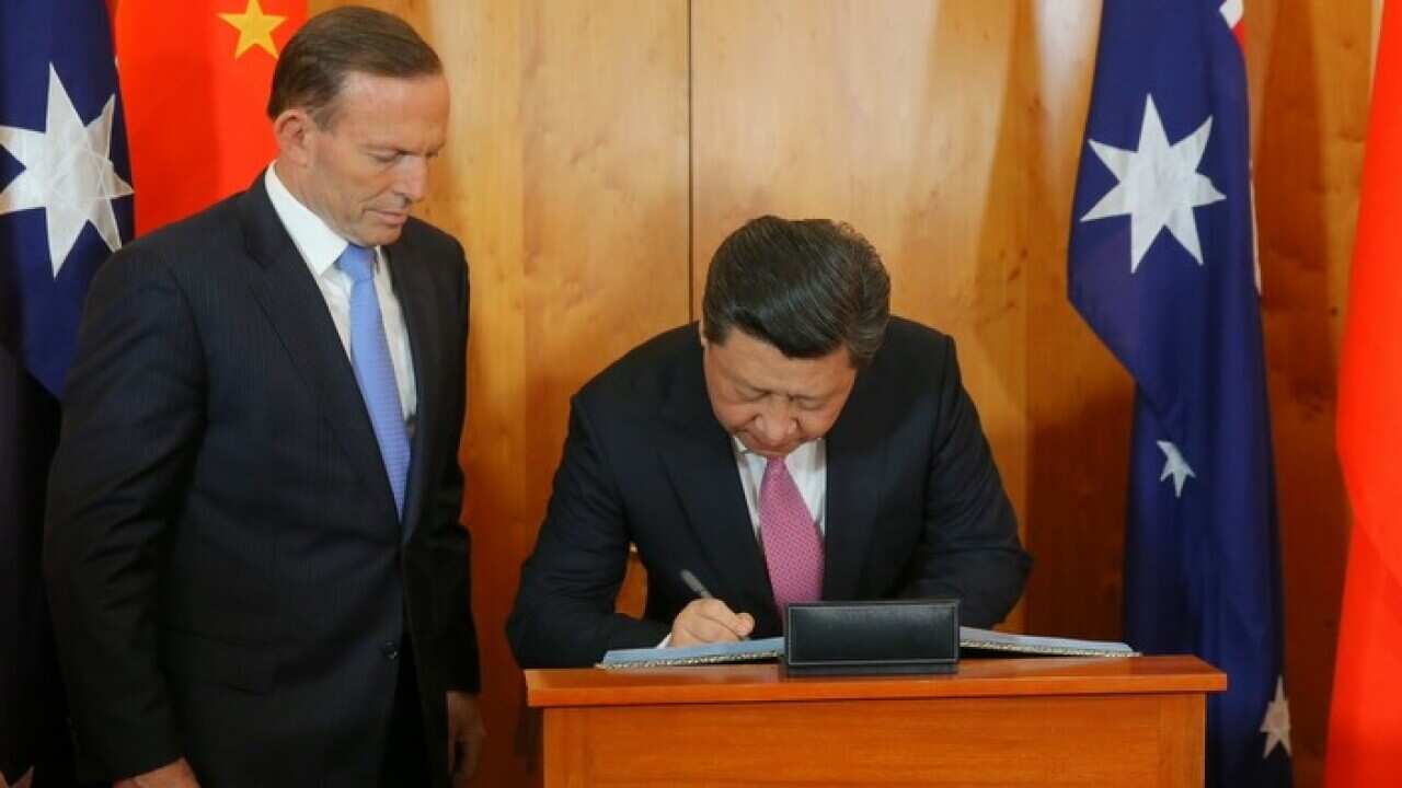 tony_abbott_watches_xi_jinping_sign_guest_book_aap_larger.jpg