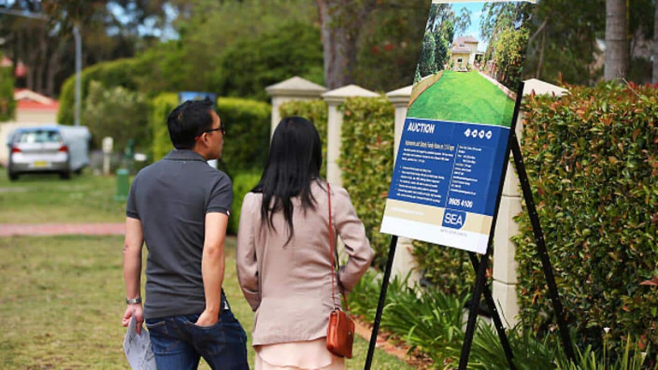 People look at a auction sign outside a property in Beacon Hill, Sydney, Australia