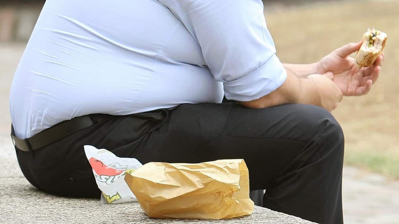 Οverweight man eating fast food.