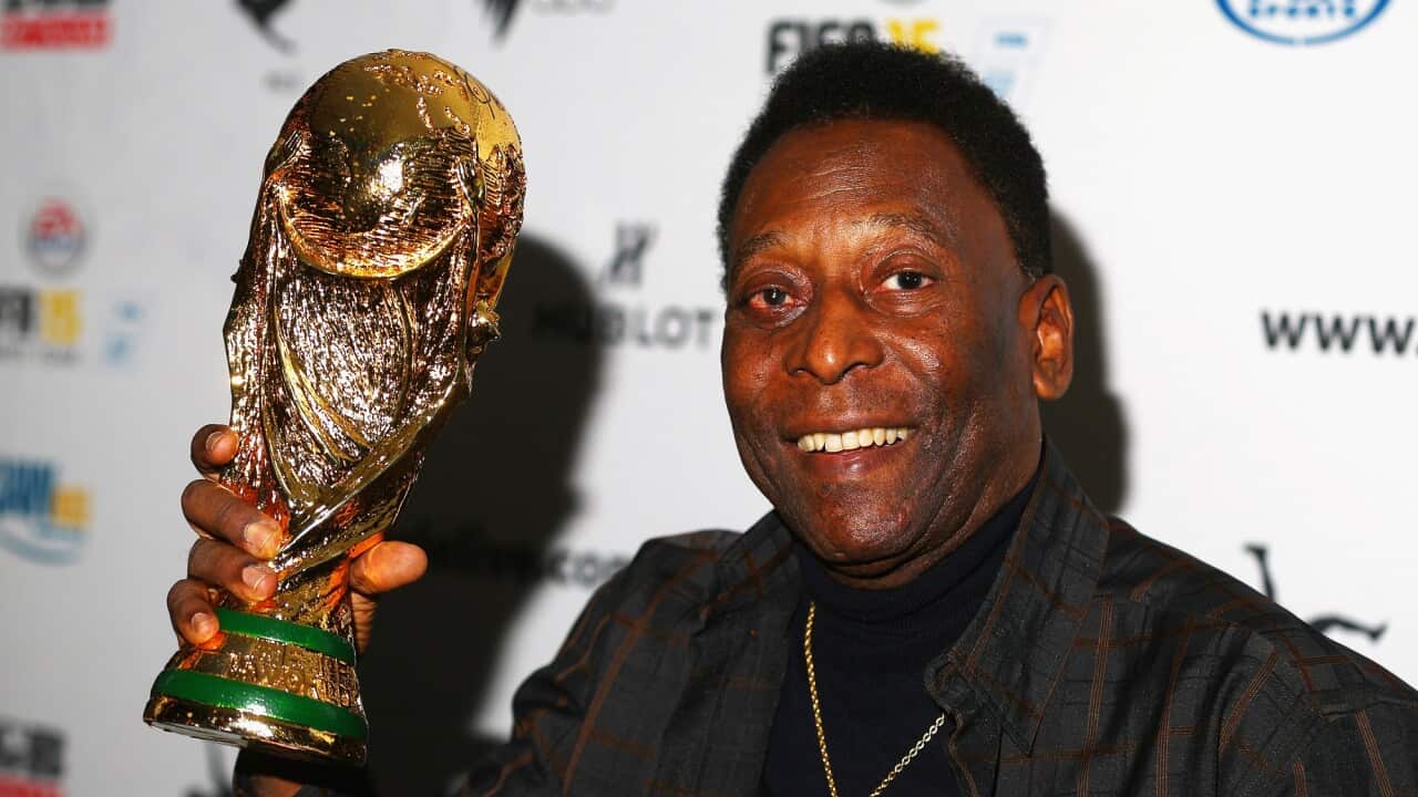 Pele holds a replica World Cup trophy during a press conference in Melbourne on 26 March 2015.