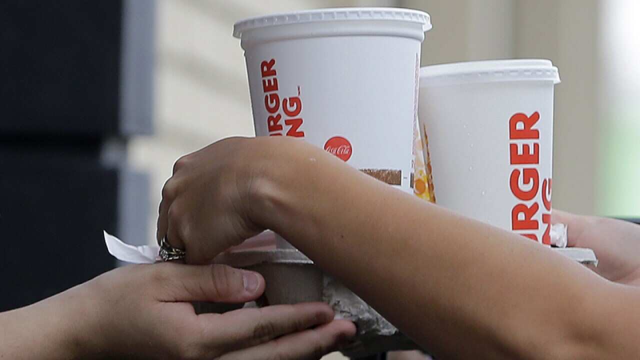 A customer picks up his order at a Burger King drive-thru