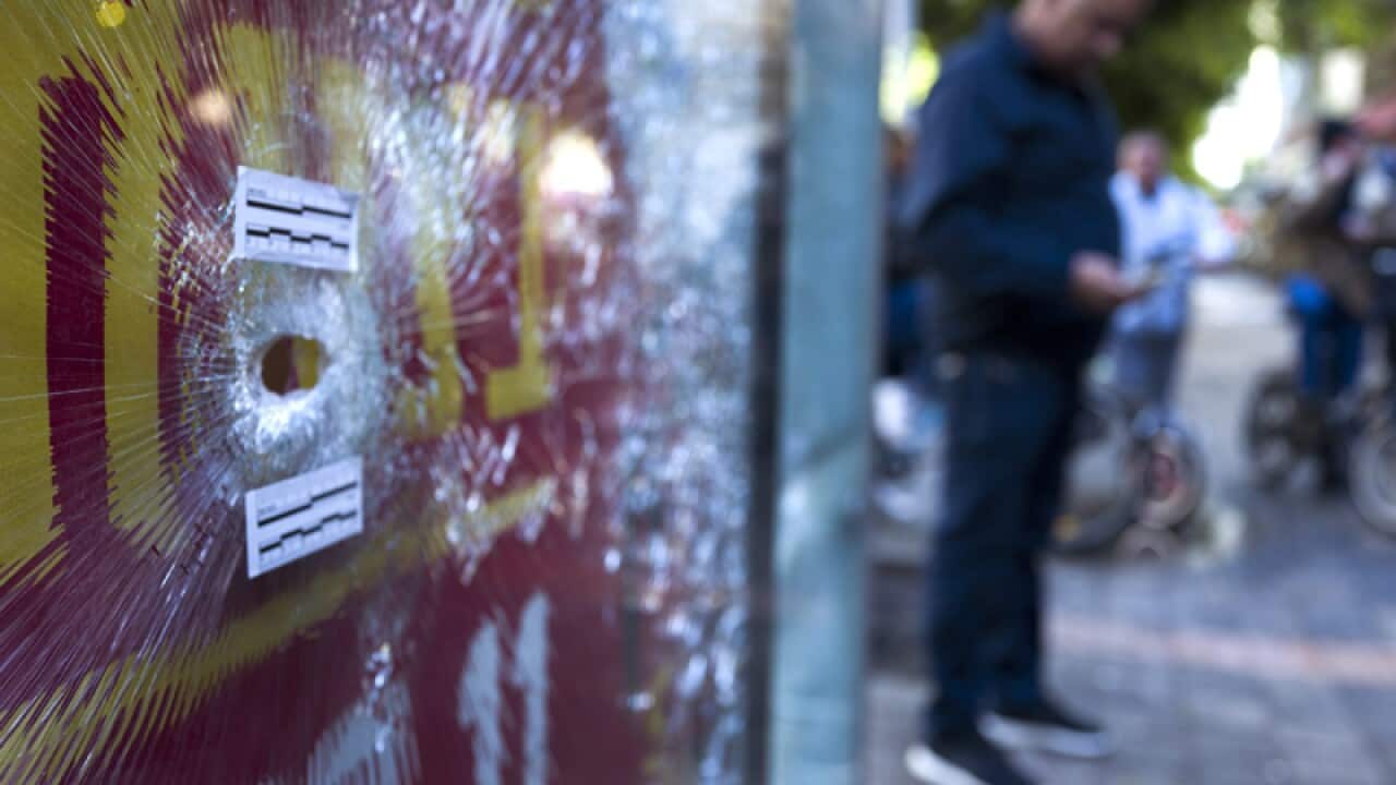 A bullet hole in an advertising panel in front of a cafe in Tel Aviv