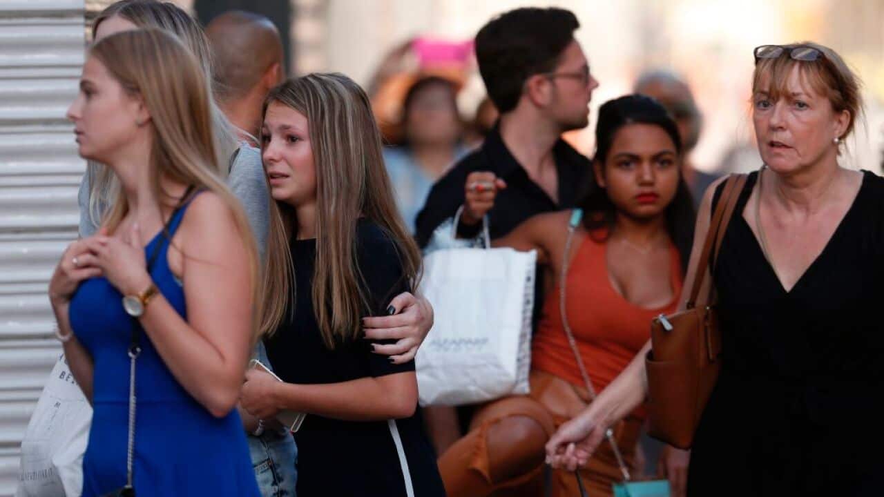 People react as they leave a cordoned off area after a van ploughed into the crowd
