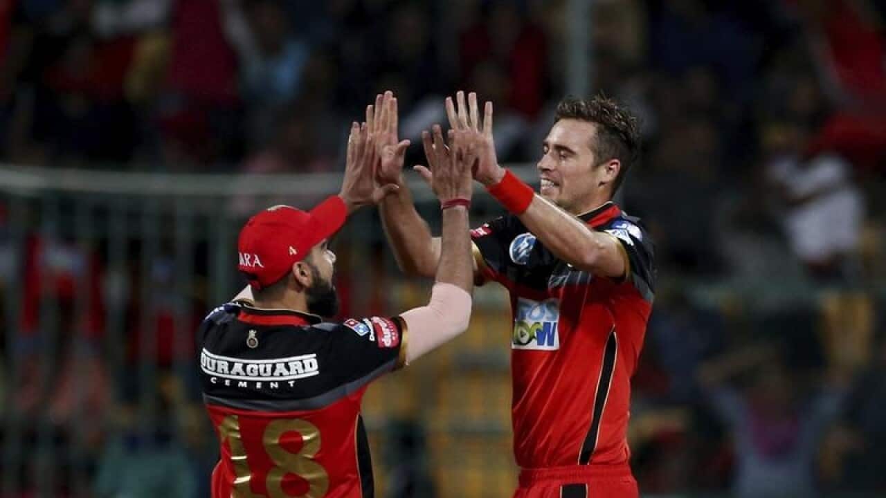 Virat Kohli and Tim Southee celebrate.