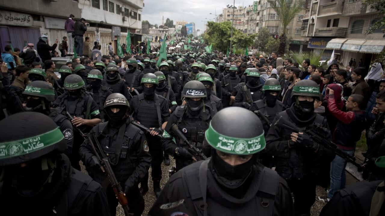 Palestinian Hamas masked gunmen display their military skills during a rally to commemorate the 27th anniversary of the Hamas militant group. (AP Photo/Khalil Hamra)