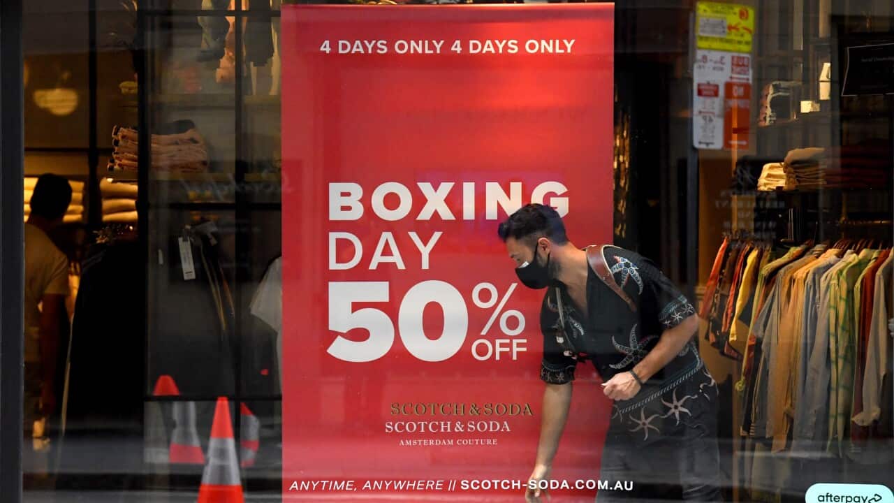 A shopping attendant is seen at a menswear store during Boxing Day sales at Pitt Street Mall in Sydney, Sunday, December 26, 2021.