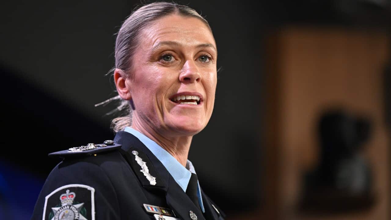 A woman in a police uniform mid-speech.