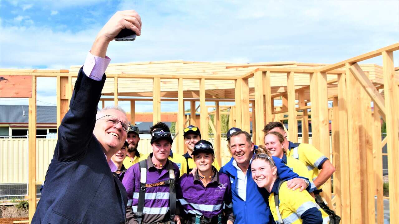 (L-R) Prime Minister Scott Morrison takes a selfie with Liberal member for Braddon Gavin Pearce and apprentices on a building site in Spreyton, Tasmania, Sunday, April 3, 2022. (AAP Image/Sarah Rhodes) NO ARCHIVING