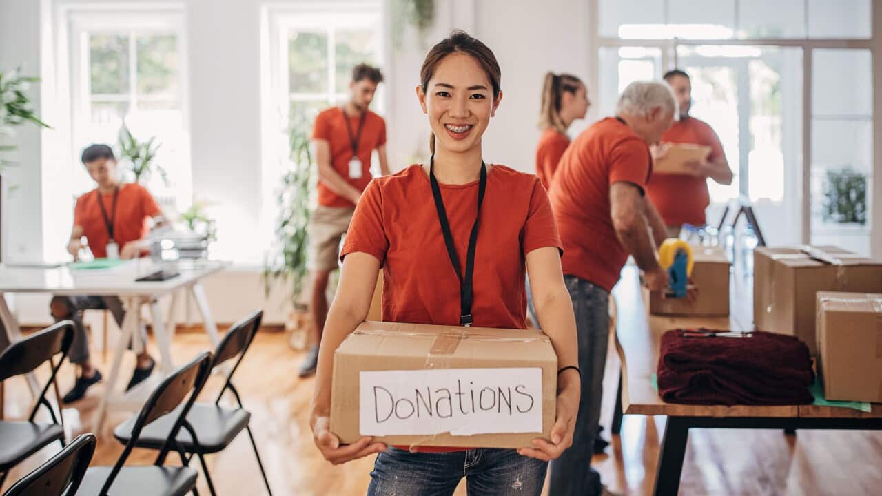 Portrait of volunteer holding donation box with goods for people in need