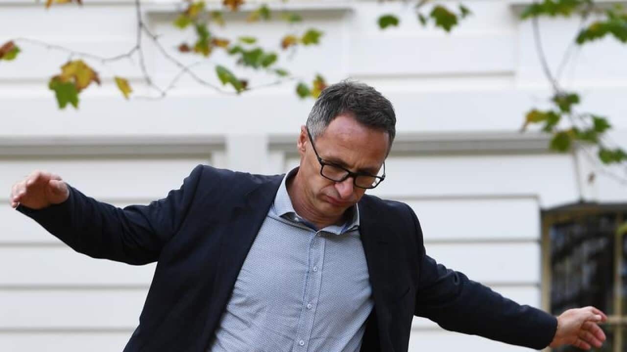 Richard Di Natale heads to a media conference in Melbourne.