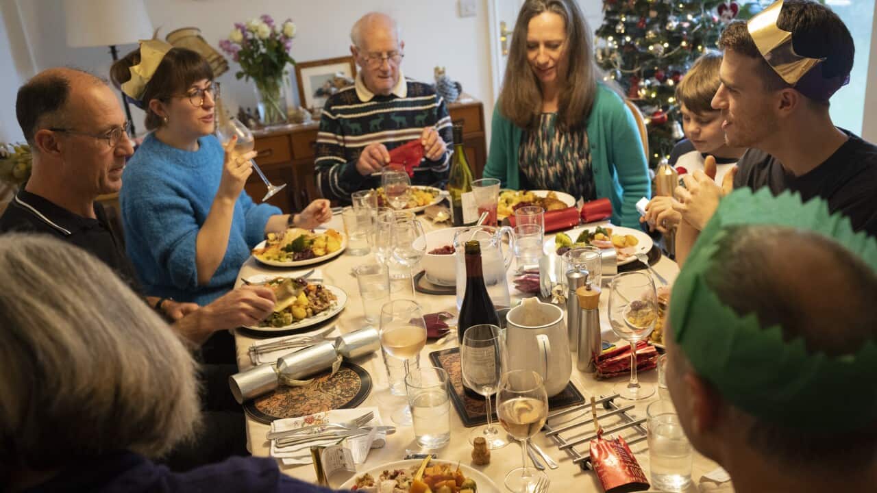 Family members sit down to eat a large Christmas Day lunch