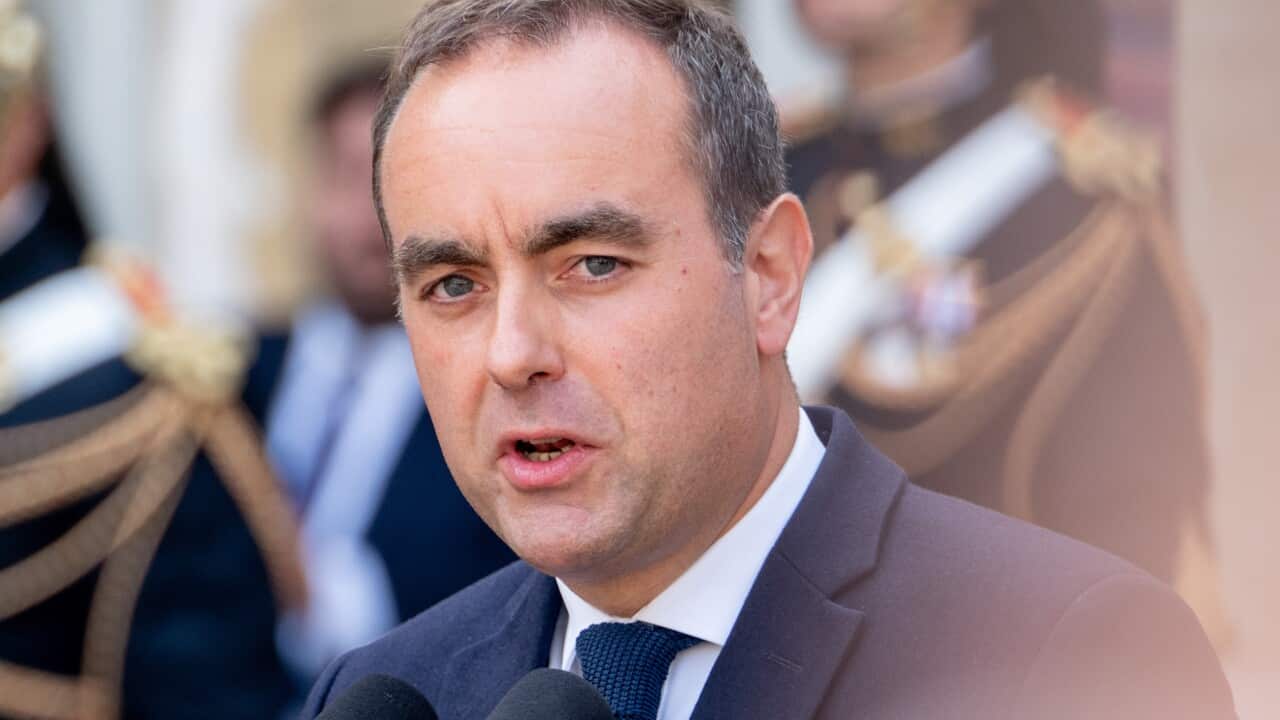 Sébastien Lecornu speaks in front of a microphone with a blurred background