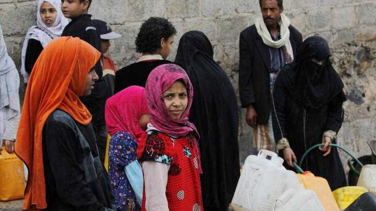 Yemenis fill jerrycans with water from a donated water pipe in Sana'a, Yemen