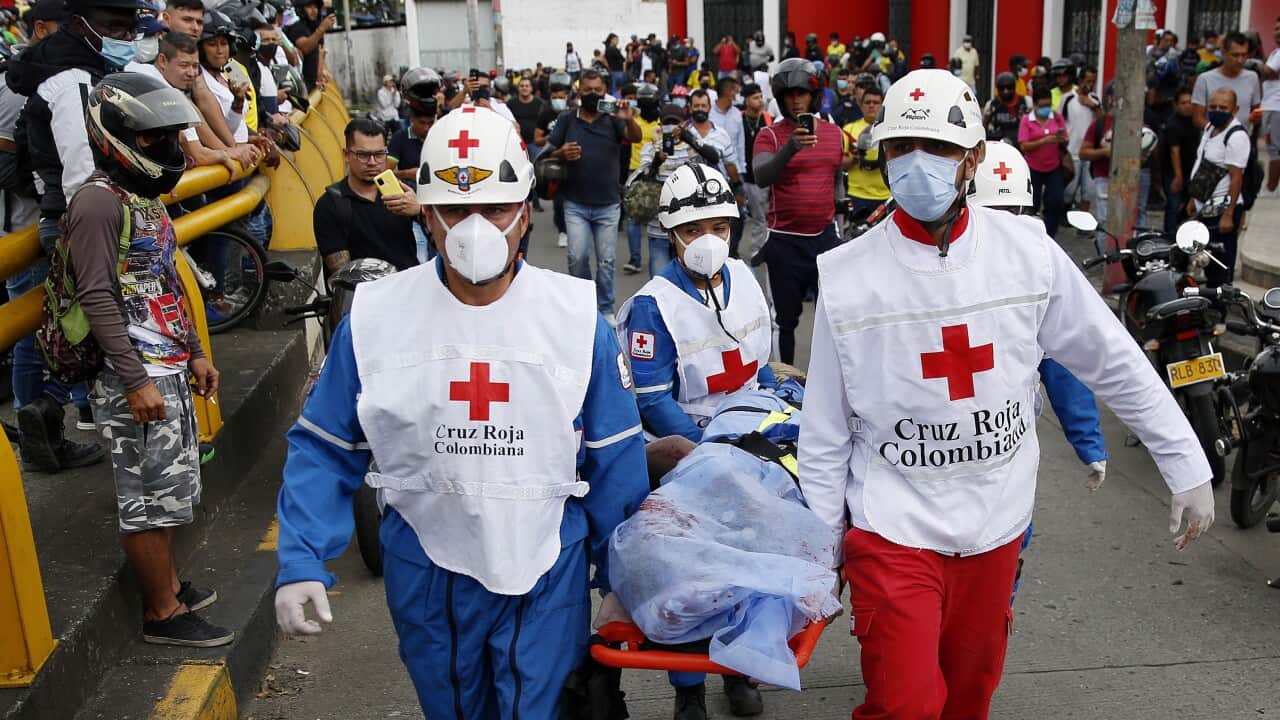 Members of the Colombian Red Cross in Cali carry an injured man away
