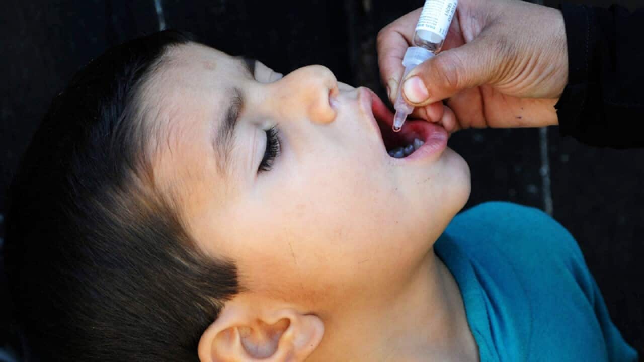 A health worker administers the Polio vaccine to a child in Karachi