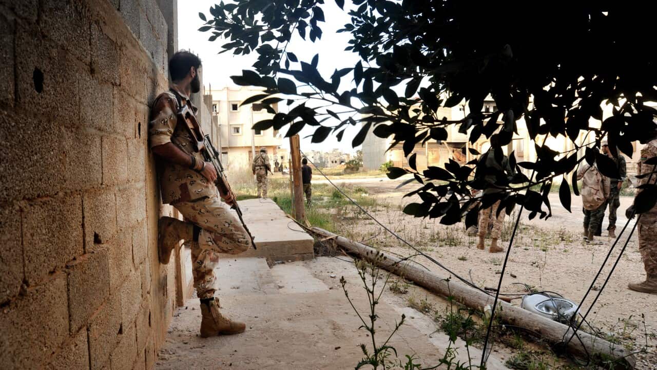 Men loyal to Libyan armed forces stand alert during clashes with Islamic State group militants west of Benghazi