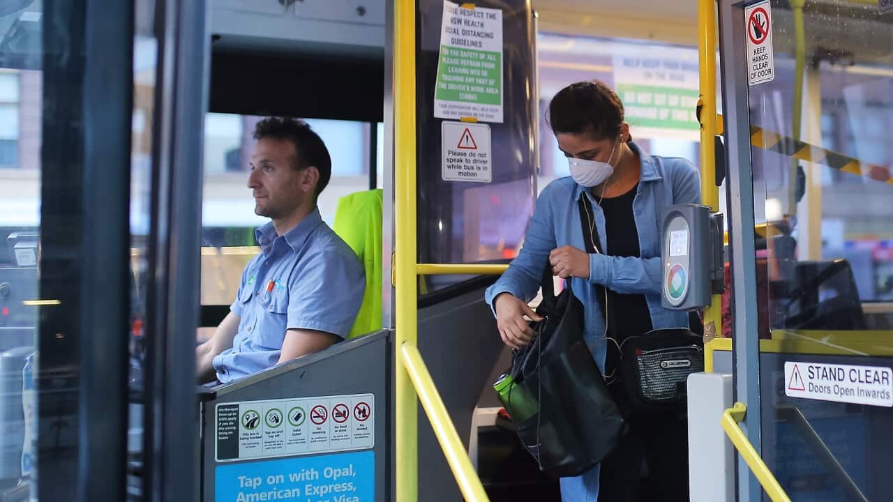 A woman wearing a mask as a preventative measure against the coronavirus disease (COVID-19) boards a public bus at Railway Square bus station in Sydney, Wednesday, April 1, 2020. (AAP Image/Steven Saphore) NO ARCHIVING