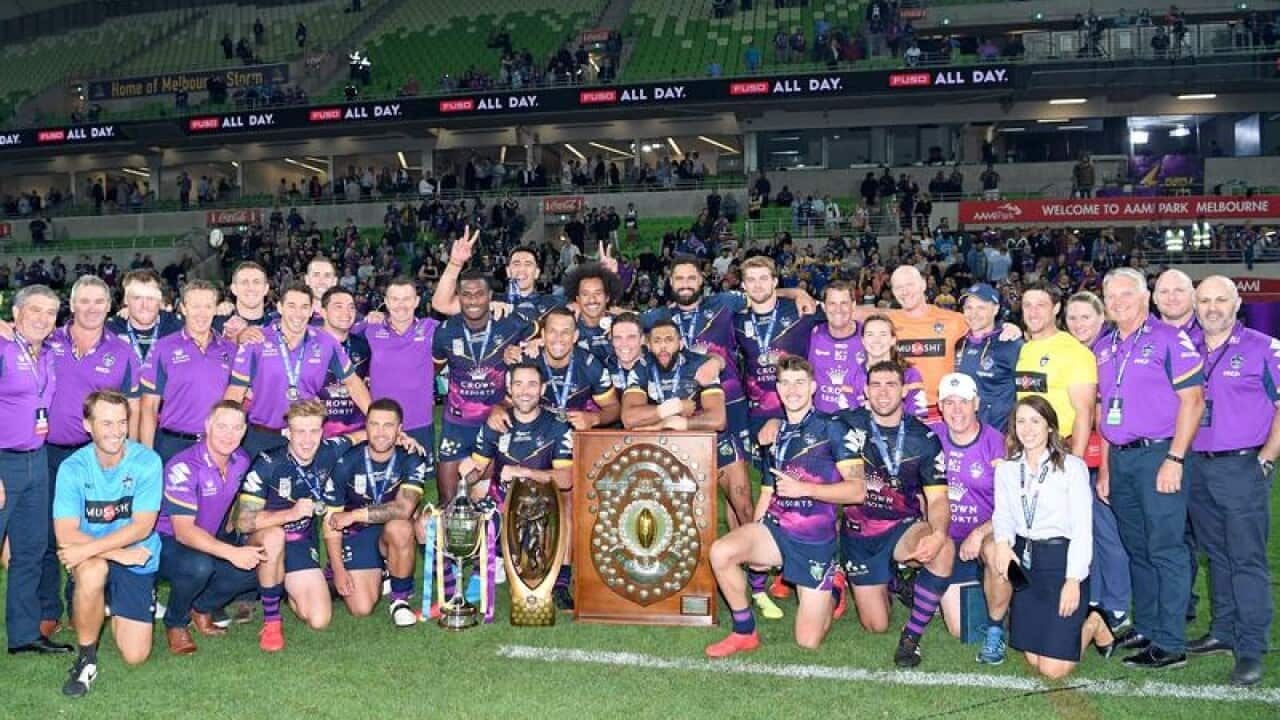 Melbourne Storm players and staff pose with their winning trophies