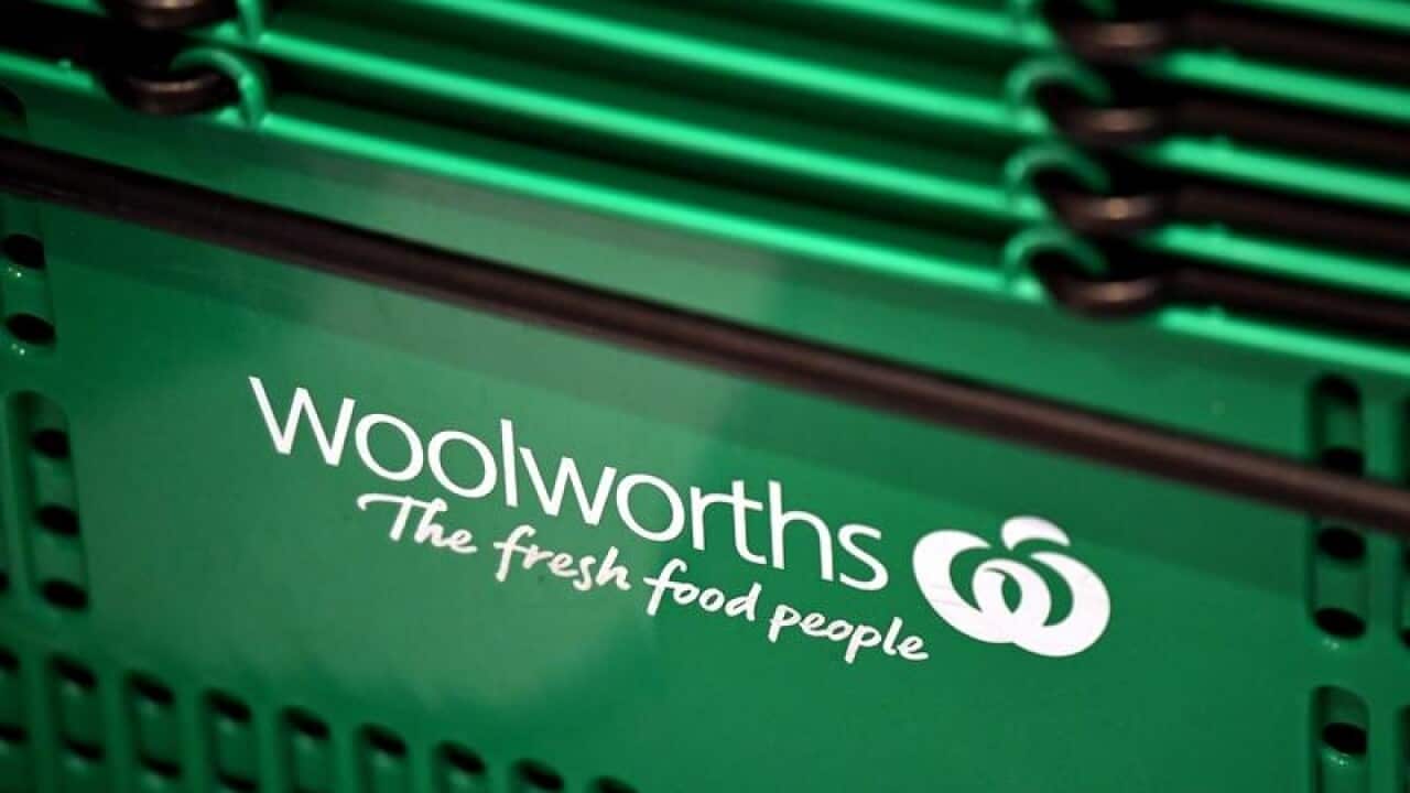 Closeup of Woolworths logo on green shopping basket stacked in a pile