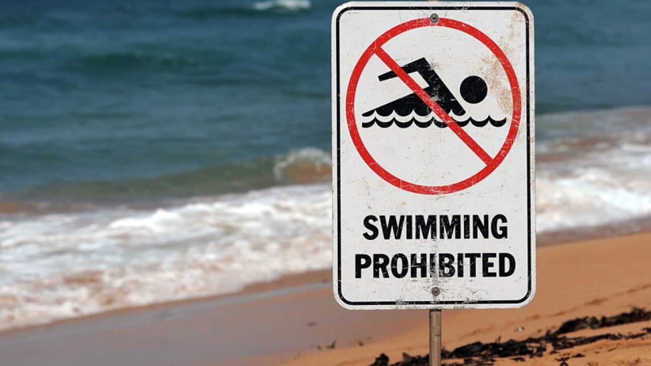 A sign warns swimmers to stay out of the water