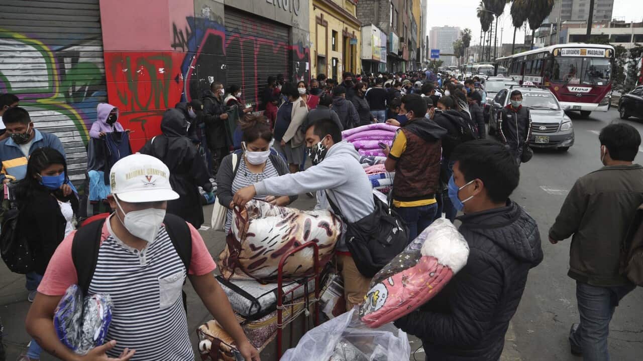 Streets vendors and shoppers wearing masks amid the spread of the new coronavirus fill a street in Lima, Peru