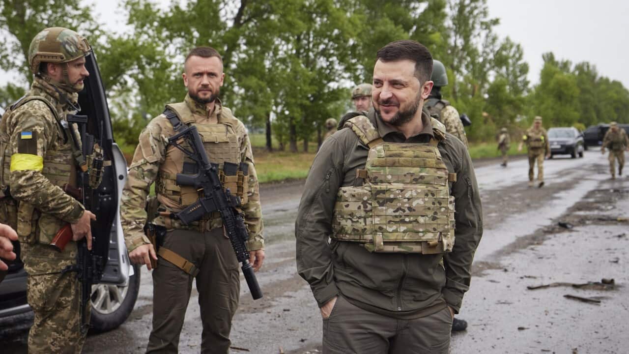 Ukrainian President Volodymyr Zelenskyy reacts as he visits the war-hit Kharkiv region