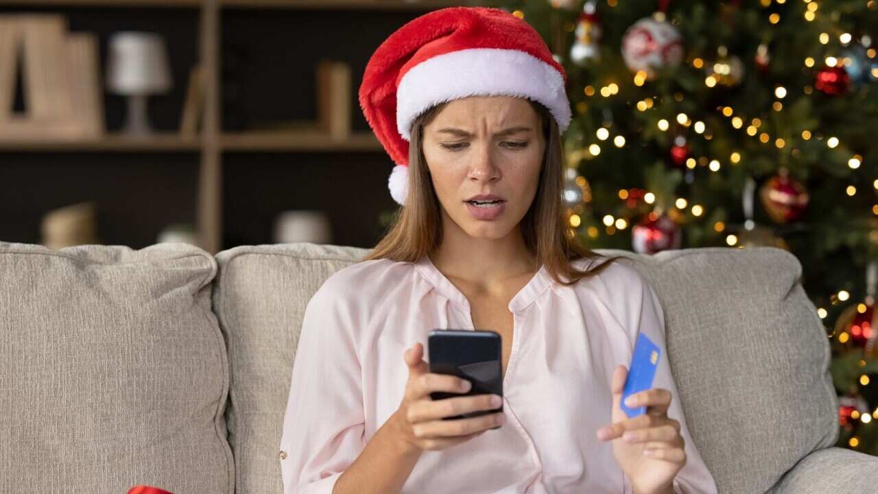Worried concerned girl in Christmas Santa hat having problems