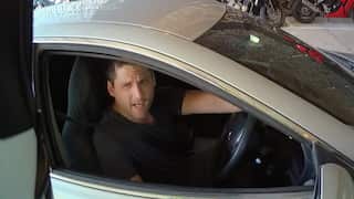 A screenshot of video from police bodycam showing a man in a car.