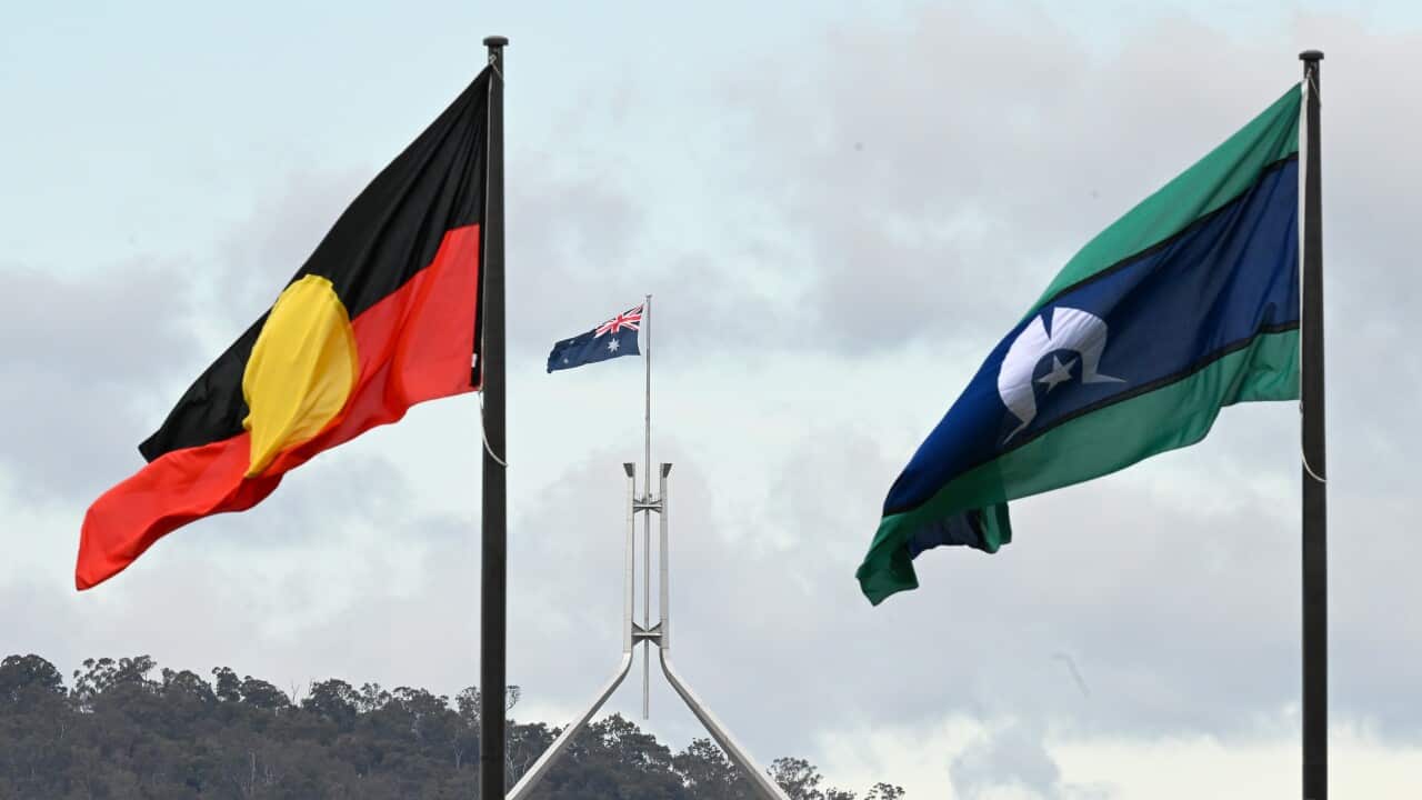 The Aboriginal and Torres Strait Islander flags fly in front of Parliament House in Canberra
