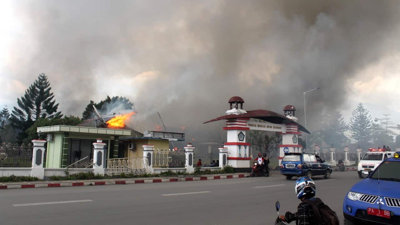 Smoke rises from a burning building during a violent rally in Wamena, Papua Province