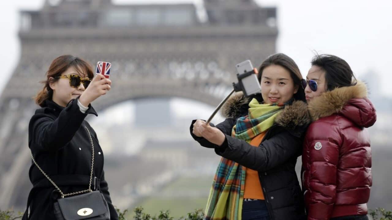 Chinese tourist selfie in front of Eiffel Tower