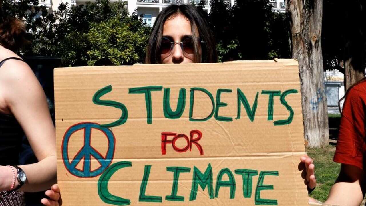 Student holding placard protesting about climate change