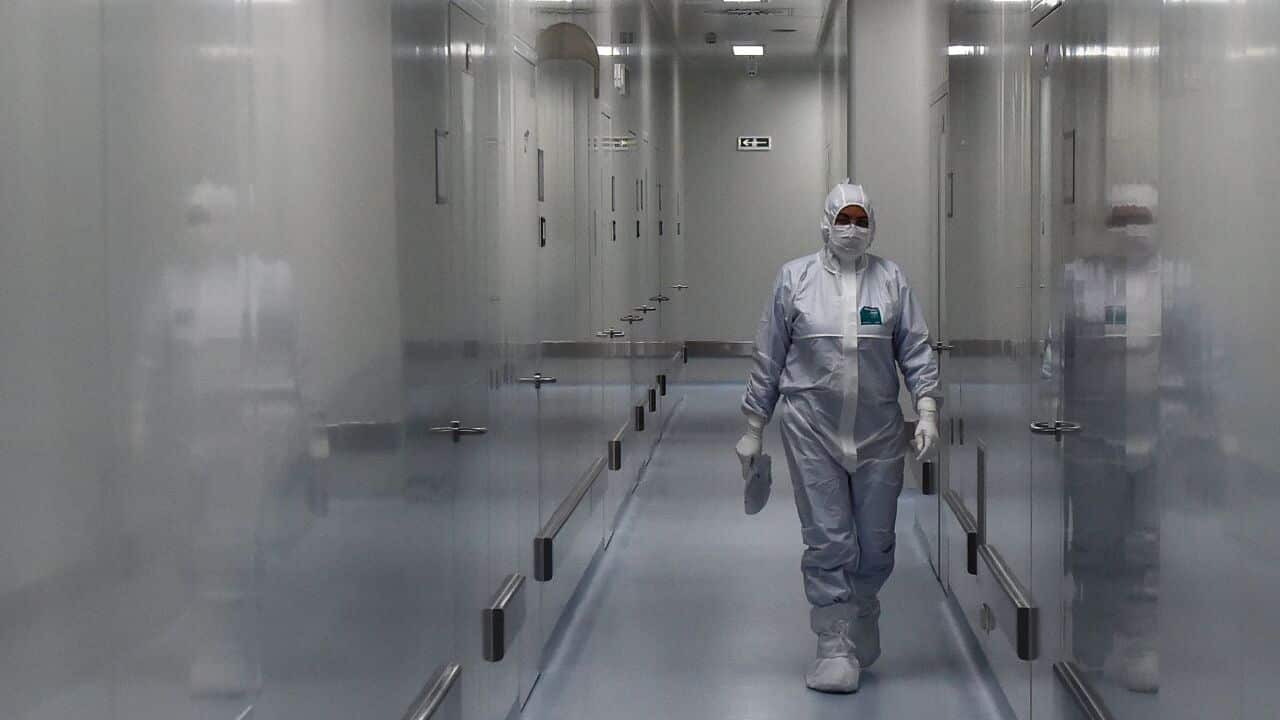 An employee wearing protective equipment walks in a passage at the headquarters of Russia's biotech company BIOCAD.