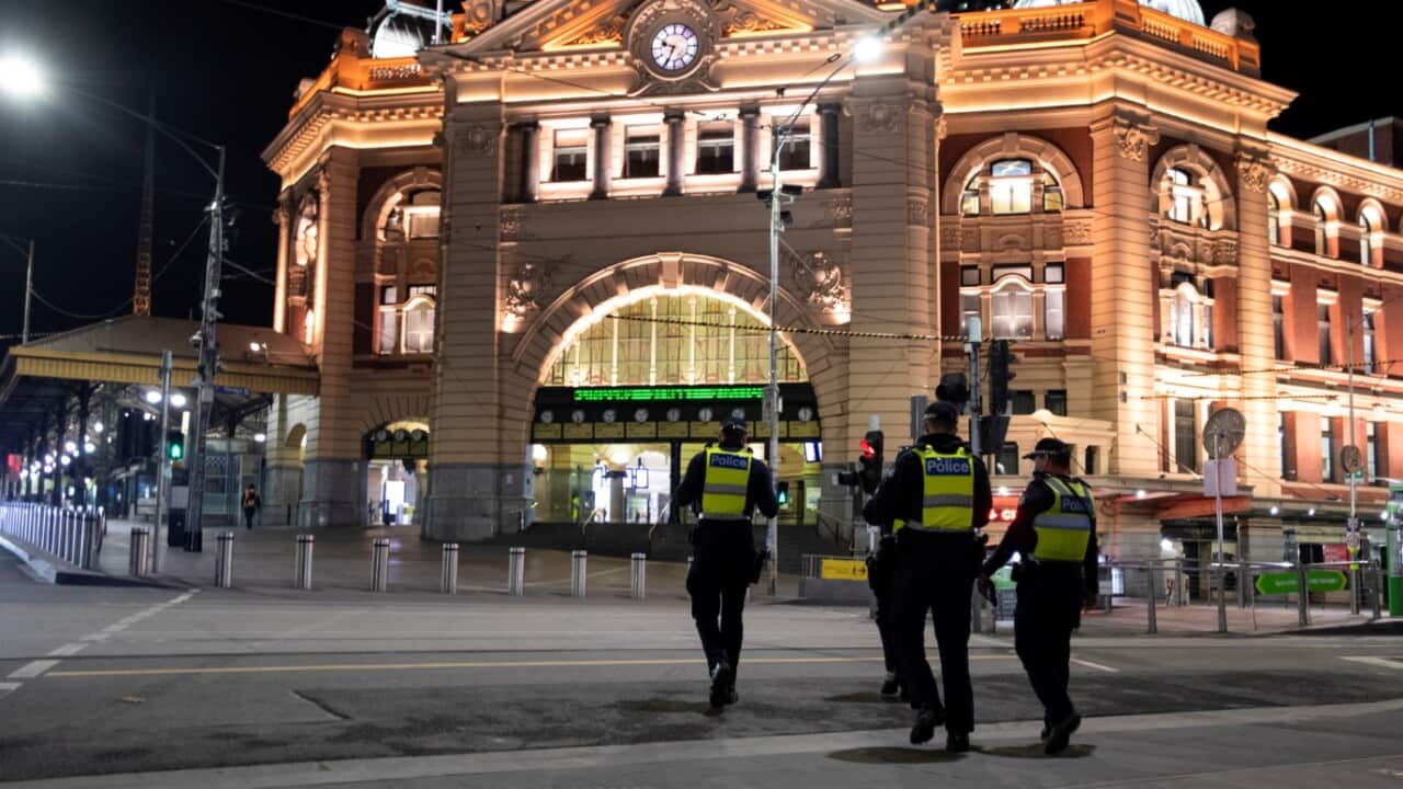 Police are seen in front of Flinders Street Station during a 8PM-5AM curfew in Melbourne, Saturday, August 8, 2020.