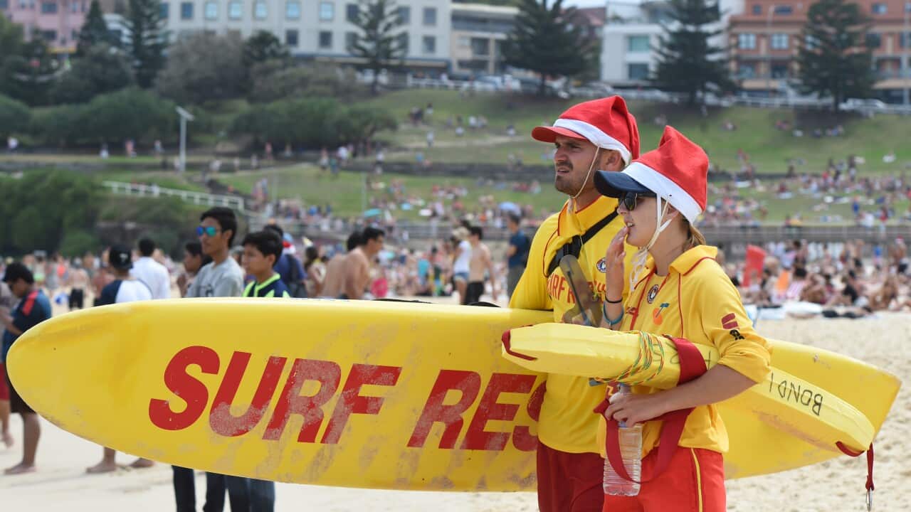 Bondi Surf Life Savers watch over thousands flock to Bondi Beach for the traditional expats Christmas Day celebration