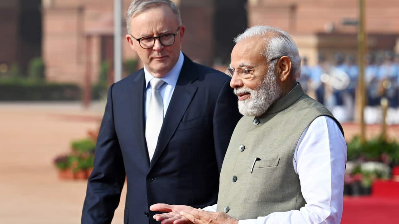 Two men wearing formal attire walking outside.