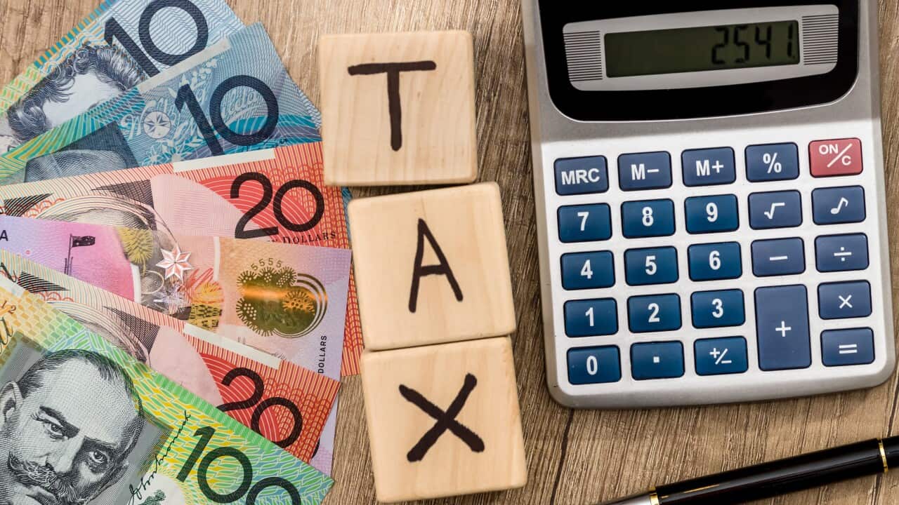 wooden cubes with text tax australian dollar pen and calculator