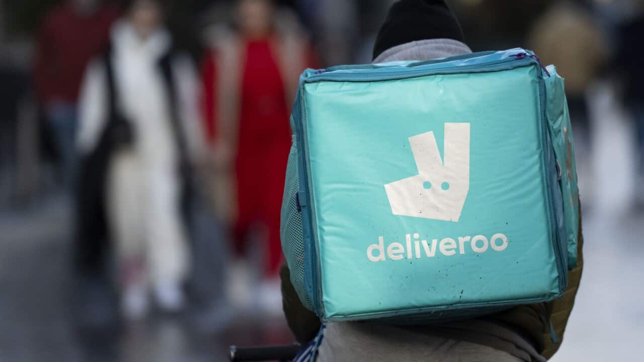 Food delivery person rides a bike with a food bag on his back