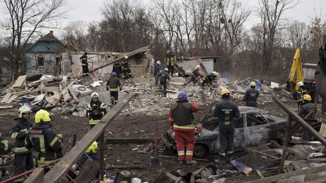 Emergency workers remove the debris of a house.