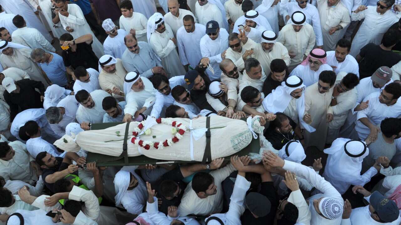 Kuwaitis attend the funeral for the victims killed in the suicide bombing on the Imam Sadiq Mosque in al-Sawaber, at the Sulaibikhat Cemetery, Kuwait, 27 June 2015. (EPA/RAED QUTENA)