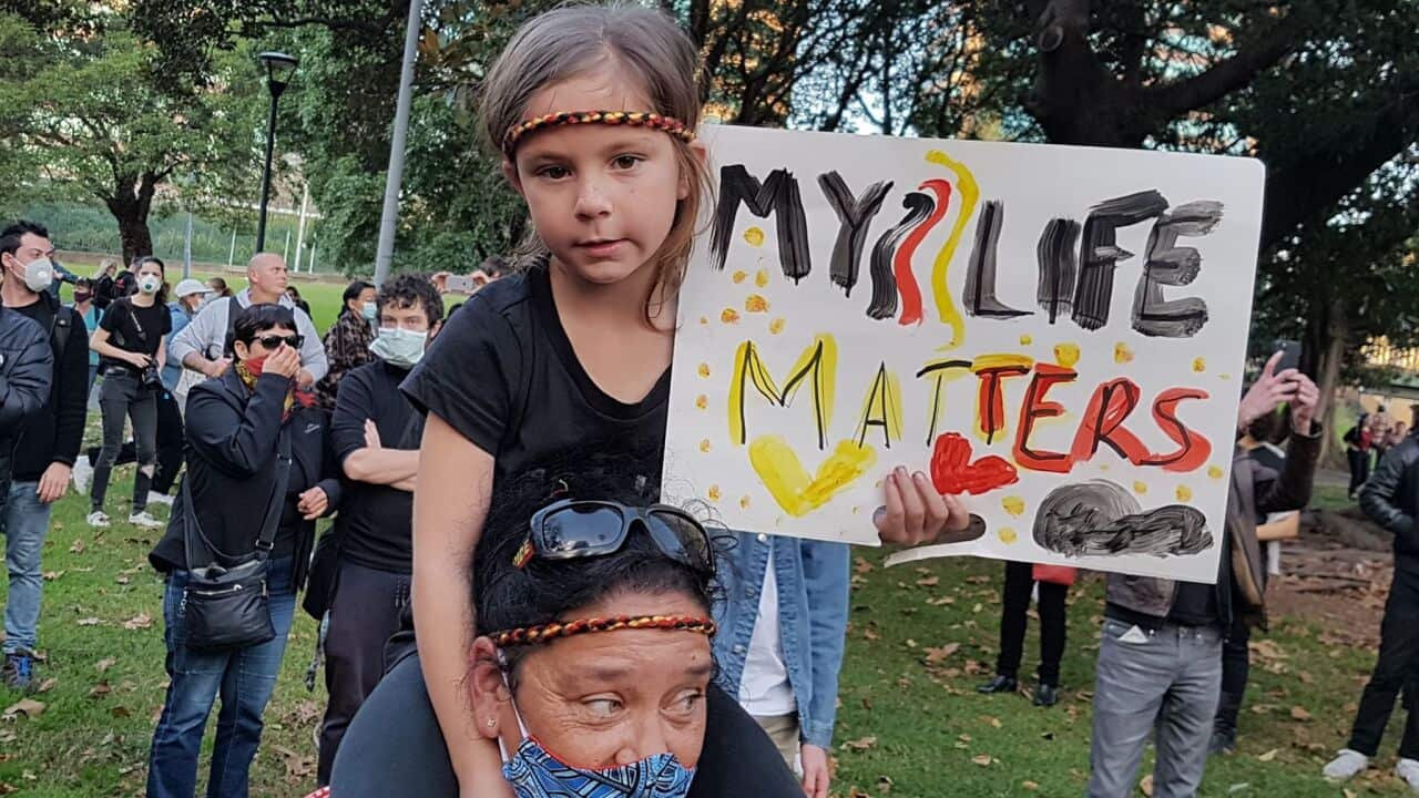 A young girl holds up a sign during the Sydney protest