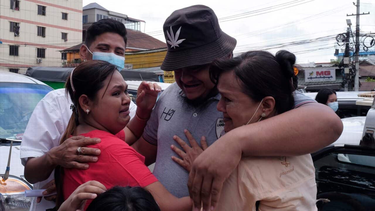 A man is embraced by two women outside Insein prison in Yangon on 17 April, as Myanmar's junta released more than 23,000 prisoners to mark the new year holiday.