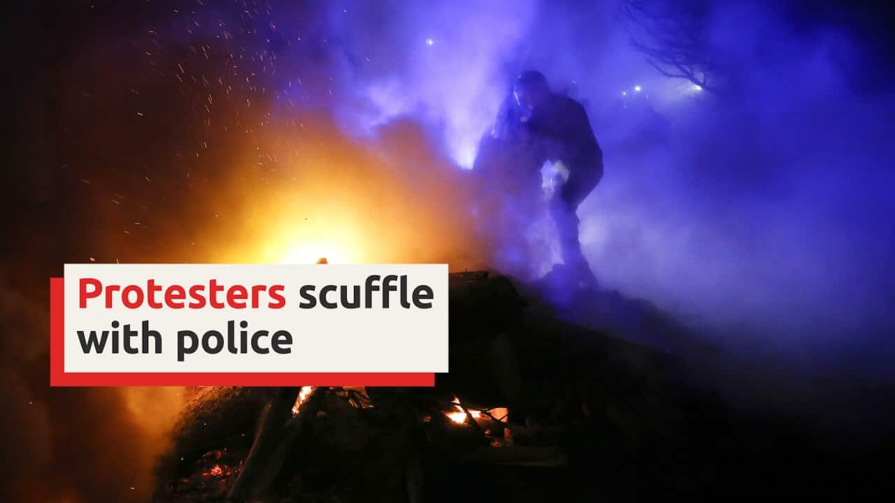 Protesters scuffle with police as China evacuees arrive in Ukrainian village